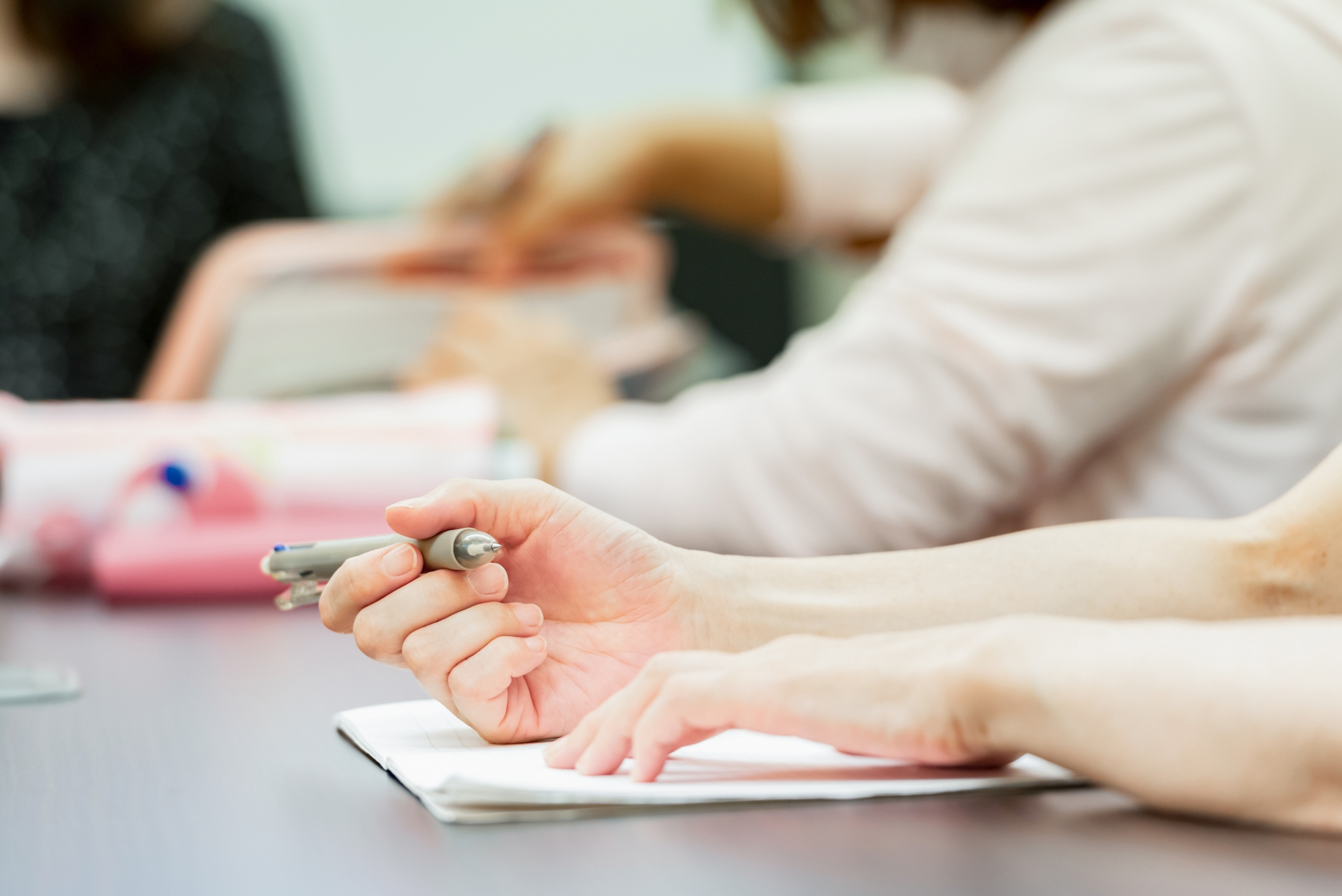 ノートにメモをしている人